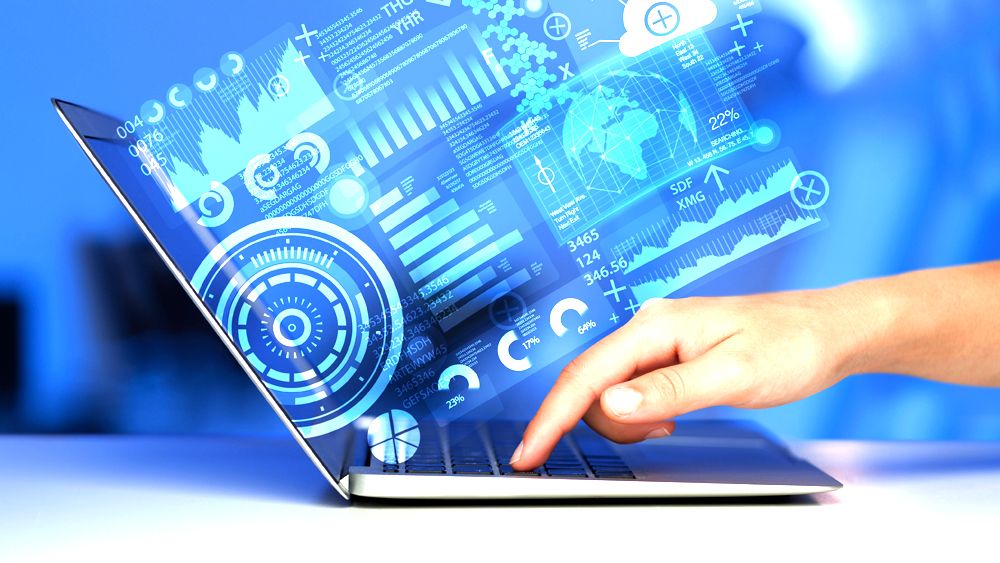 Hand touching a laptop with glowing data charts